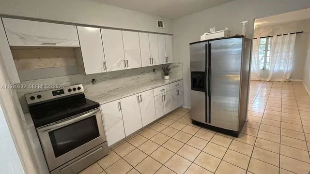 a kitchen with granite countertop a refrigerator and a stove