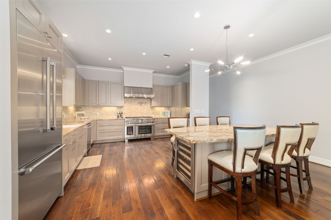 2221 Welch Street, Unit 201 Houston, TX 77019 - Photo 22 of 49 Notice how the engineered hardwood floors flow throughout the main living spaces, complementing custom cabinetry and the oversized island with its built-in beverage/wine fridge, creating an open, airy feel that lives like a private residence.