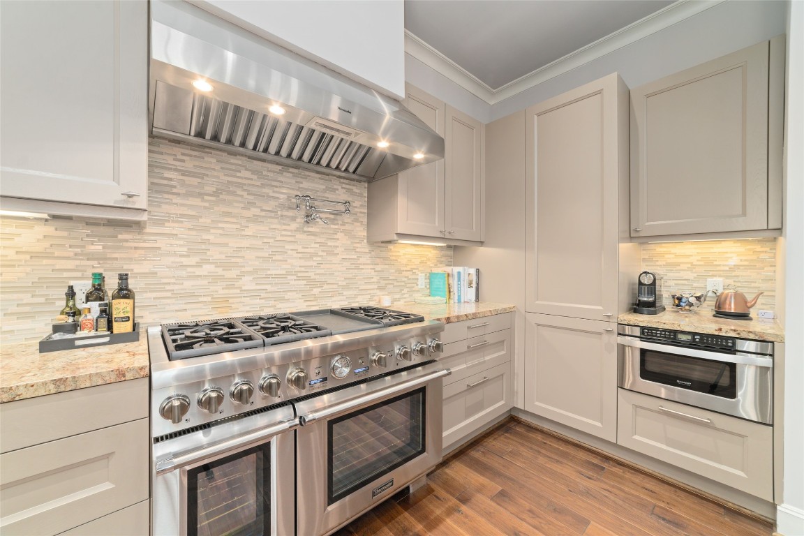2221 Welch Street, Unit 201 Houston, TX 77019 - Photo 24 of 49 An industrial-sized Thermador vent hood sits above the range, paired with a convenient pot filler below, delivering both refined design and professional-level performance.