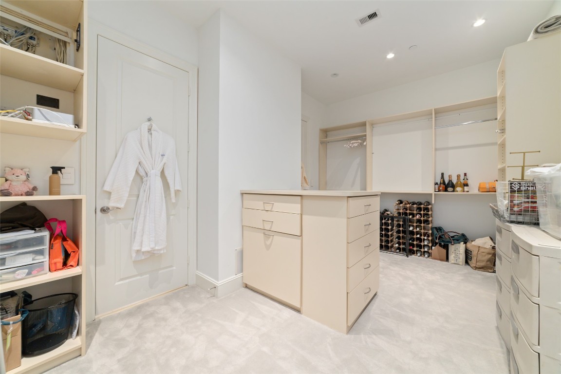 2221 Welch Street, Unit 201 Houston, TX 77019 - Photo 41 of 49 A center island with cabinet storage separates the two sides of the expansive closet, adding extra organization and functionality to the space.