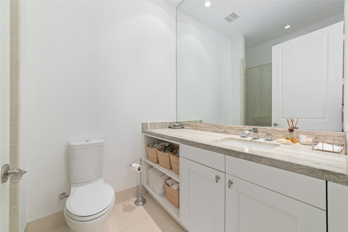 2221 Welch Street, Unit 201 Houston, TX 77019 - Photo 9 of 49 a bathroom with a granite countertop toilet sink and mirror