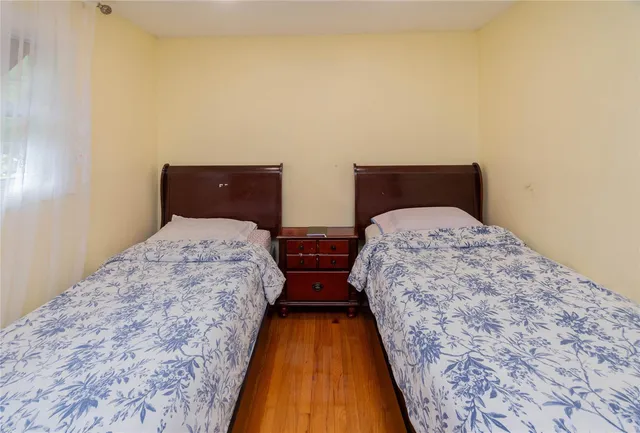a bedroom with bed and wooden floor