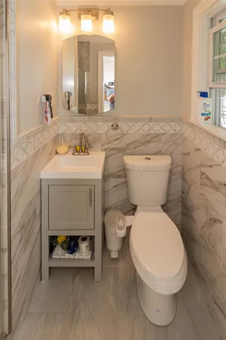 a bathroom with a sink a toilet and mirror