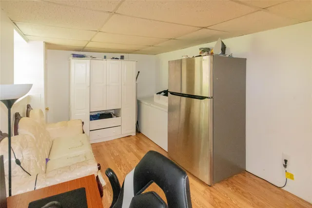 a bedroom with a bed and a refrigerator