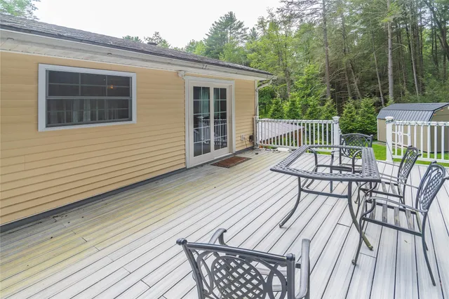 a balcony with wooden floor table and chairs