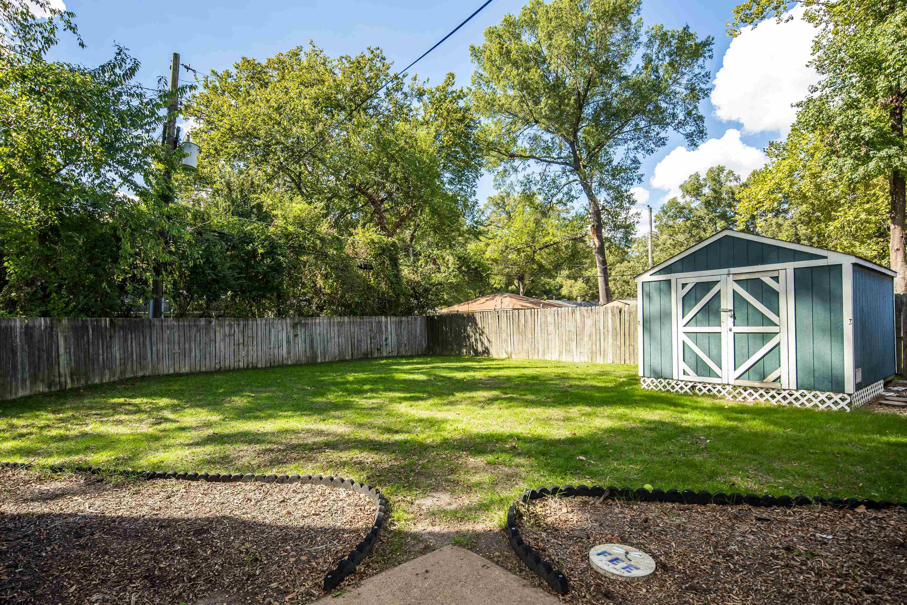 1269 West Perkins Road Memphis, TN 38117 - Photo 28 of 31 a view of a backyard with small plants and large trees