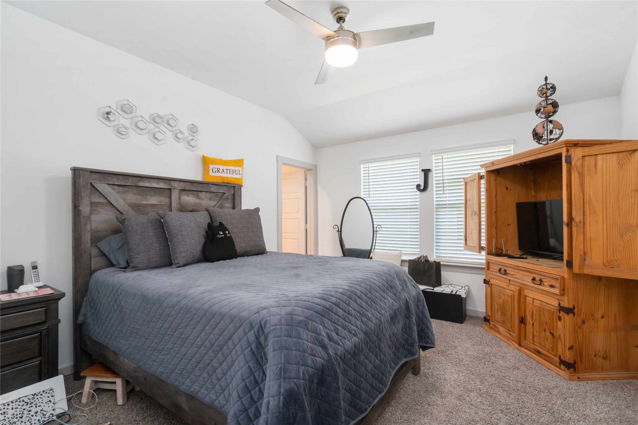 7730 Robert Rosharon, TX 77583 - Photo 11 of 18 Spacious primary bedroom with tray ceiling, neutral palette, and ample natural light for a peaceful retreat.