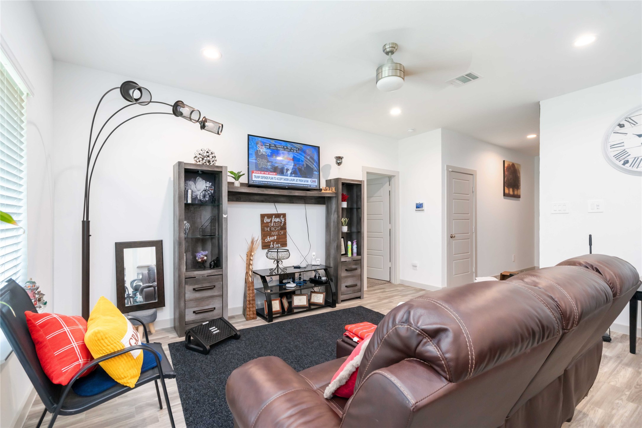7730 Robert Rosharon, TX 77583 - Photo 3 of 18 Bright and open living area with soaring ceilings, abundant natural light, and elegant wood-look flooring for a warm, contemporary feel.
