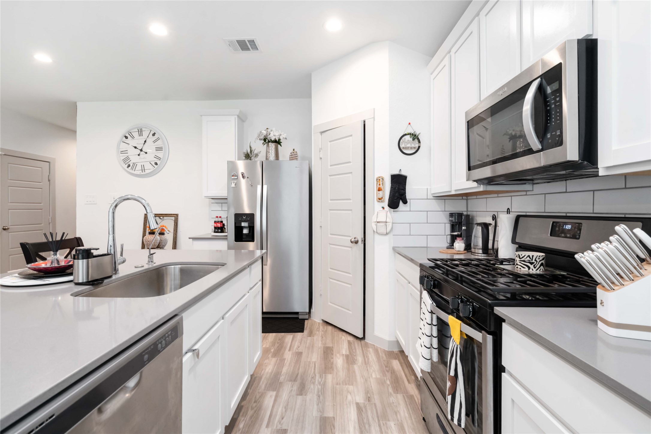 7730 Robert Rosharon, TX 77583 - Photo 8 of 18 Stylish kitchen boasts quartz countertops, stainless steel appliances, white cabinetry, and a pass-through bar for easy entertaining.