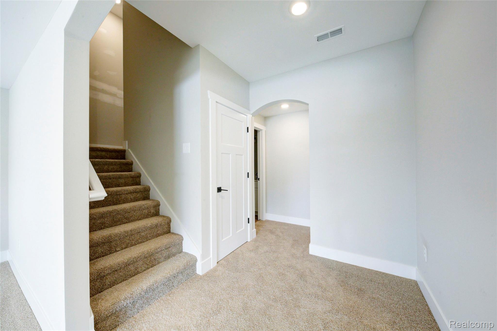 579 Round Rock (moh80) Howell, MI 48843 - Photo 29 of 42 Staircase with arched walkways, carpet floors, and recessed lighting