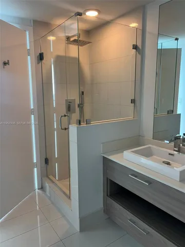 a bathroom with a sink a shower and a mirror