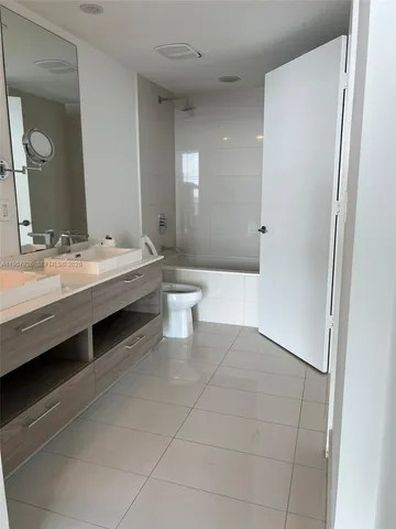 a bathroom with a double vanity sink a toilet and a mirror