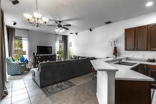 a living room with furniture a chandelier and a flat screen tv