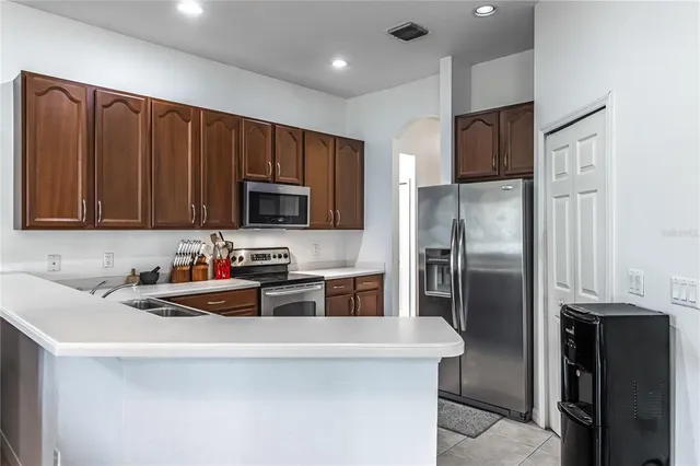 a kitchen with stainless steel appliances granite countertop a refrigerator a stove a sink and a microwave