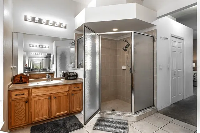 a spacious bathroom with a mirror a shower and a sink