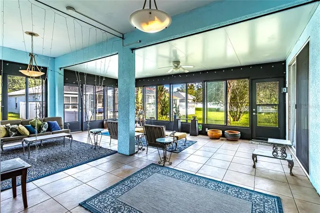 a living room with furniture large window and chandelier