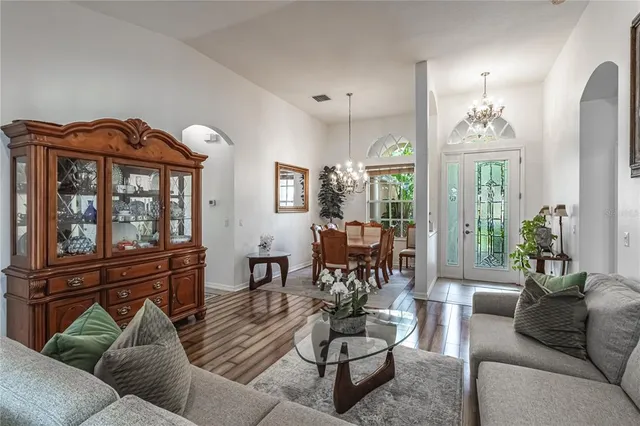 a living room with furniture a chandelier and a window