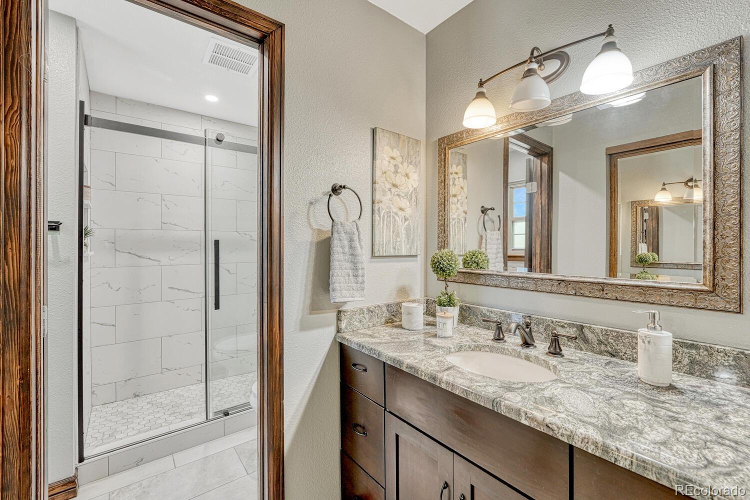 302 Northridge Road Highlands Ranch, CO 80126 - Photo 21 of 36 a bathroom with a granite countertop sink mirror and shower