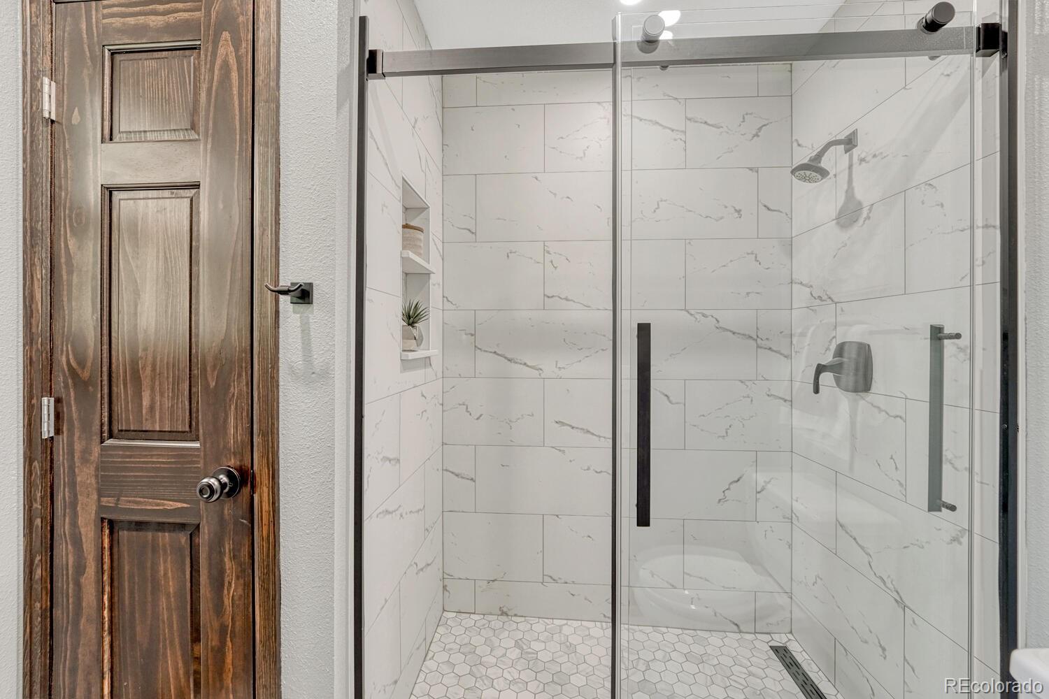 302 Northridge Road Highlands Ranch, CO 80126 - Photo 22 of 36 a bathroom with a glass shower door
