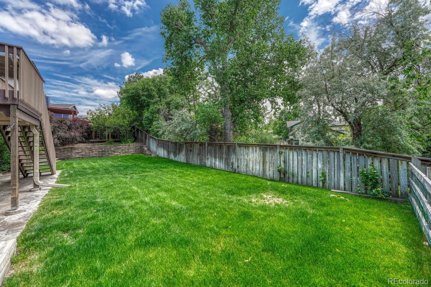 302 Northridge Road Highlands Ranch, CO 80126 - Photo 31 of 36 a view of backyard with wooden fence and a large tree