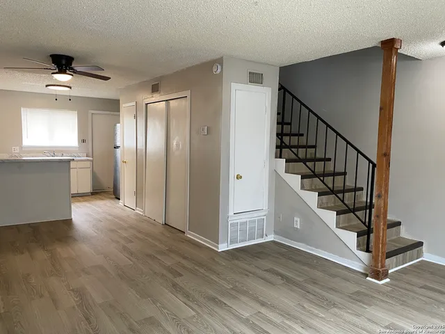 a view of a hallway with wooden floor and staircase