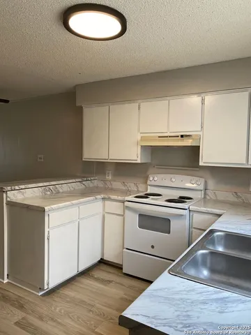 a kitchen with stainless steel appliances granite countertop a sink stove and cabinets
