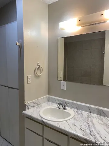 a bathroom with a granite countertop sink and a mirror