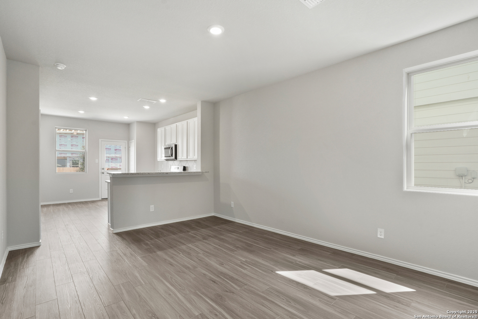 4946 Blue Ranch San Antonio, TX 78222 - Photo 2 of 32 a view of empty room with wooden floor and kitchen