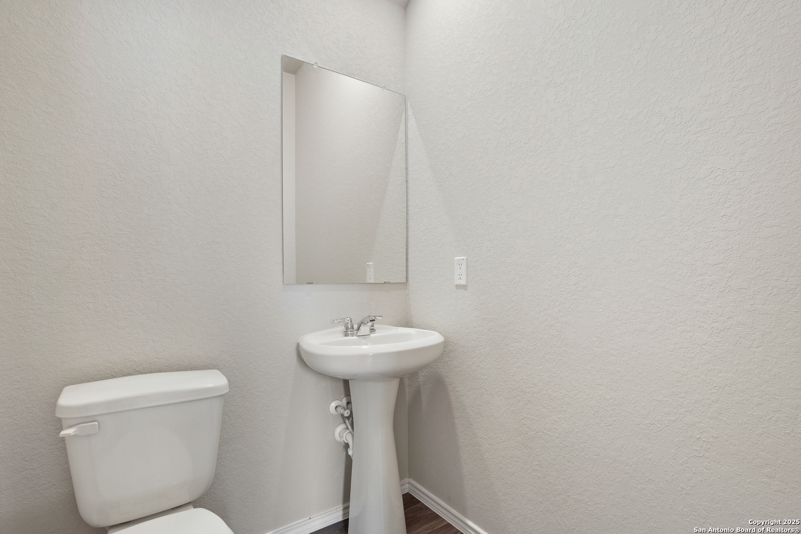 4946 Blue Ranch San Antonio, TX 78222 - Photo 8 of 32 a bathroom with a toilet sink and mirror
