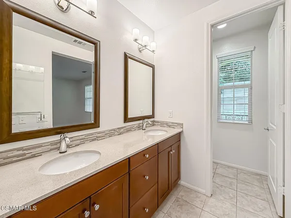 a bathroom with a granite countertop sink double and mirror