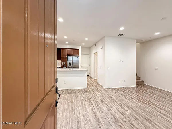 a view of a kitchen with kitchen island wooden floor center island and stainless steel appliances