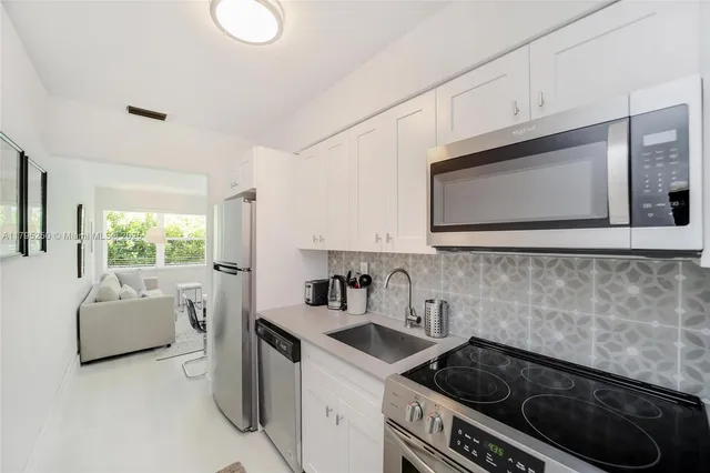 a kitchen with a stove a sink and a microwave