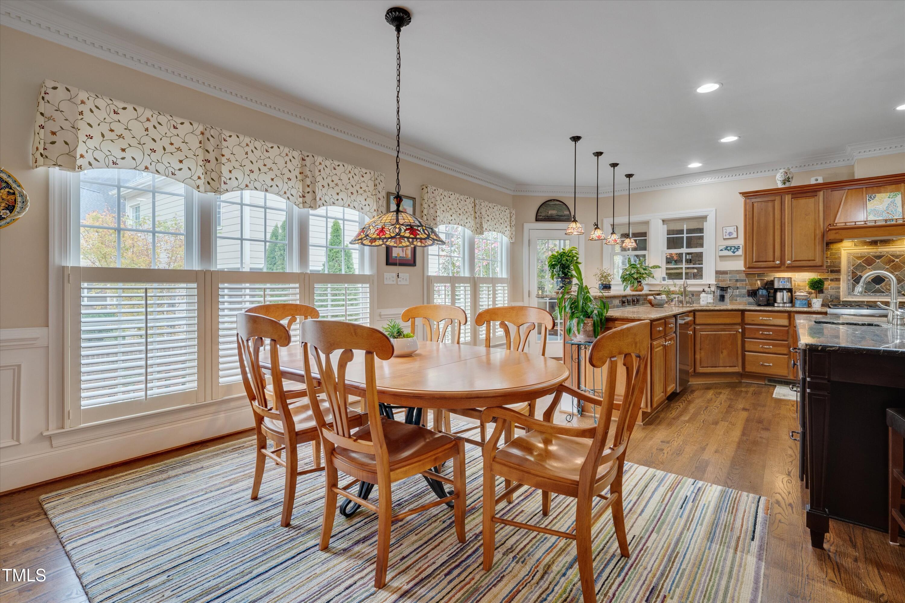 8308 Cazavini Court Raleigh, NC 27613 - Photo 18 of 46 a view of a dining room and livingroom with furniture wooden floor a chandelier