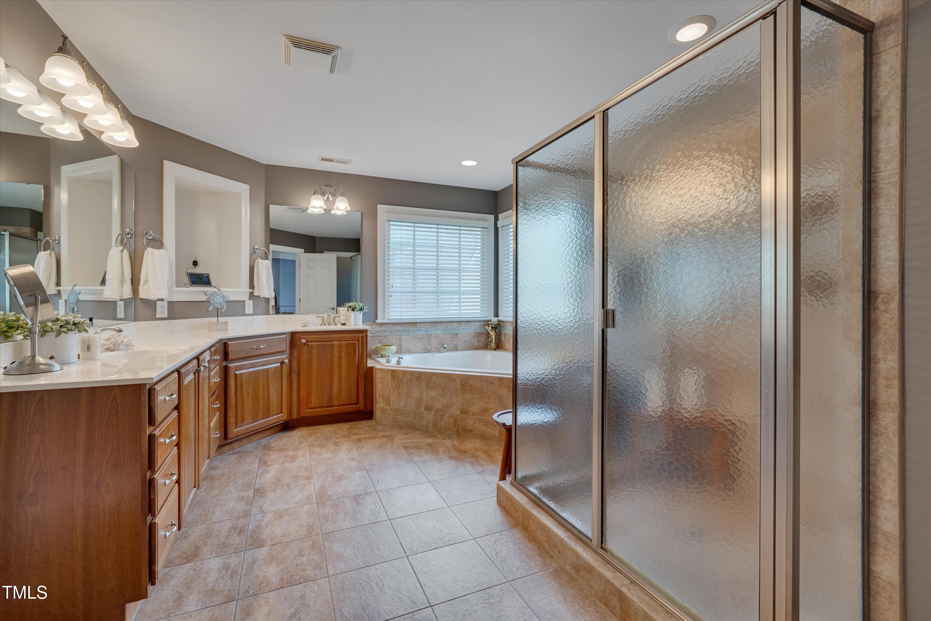 8308 Cazavini Court Raleigh, NC 27613 - Photo 31 of 46 a large bathroom with a glass shower door and a sink