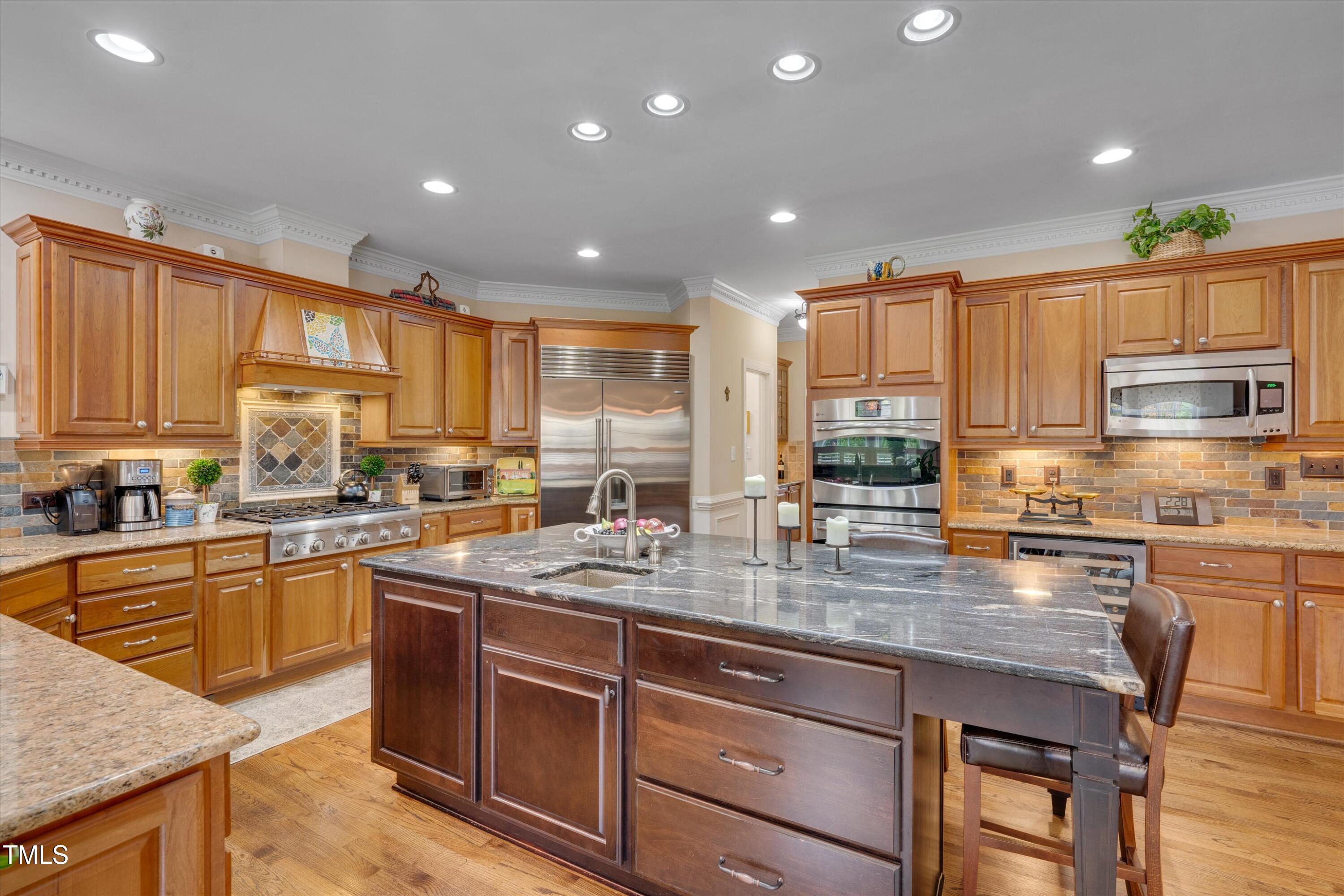8308 Cazavini Court Raleigh, NC 27613 - Photo 9 of 46 a kitchen with stainless steel appliances granite countertop wooden cabinets a stove a sink and a granite counter tops