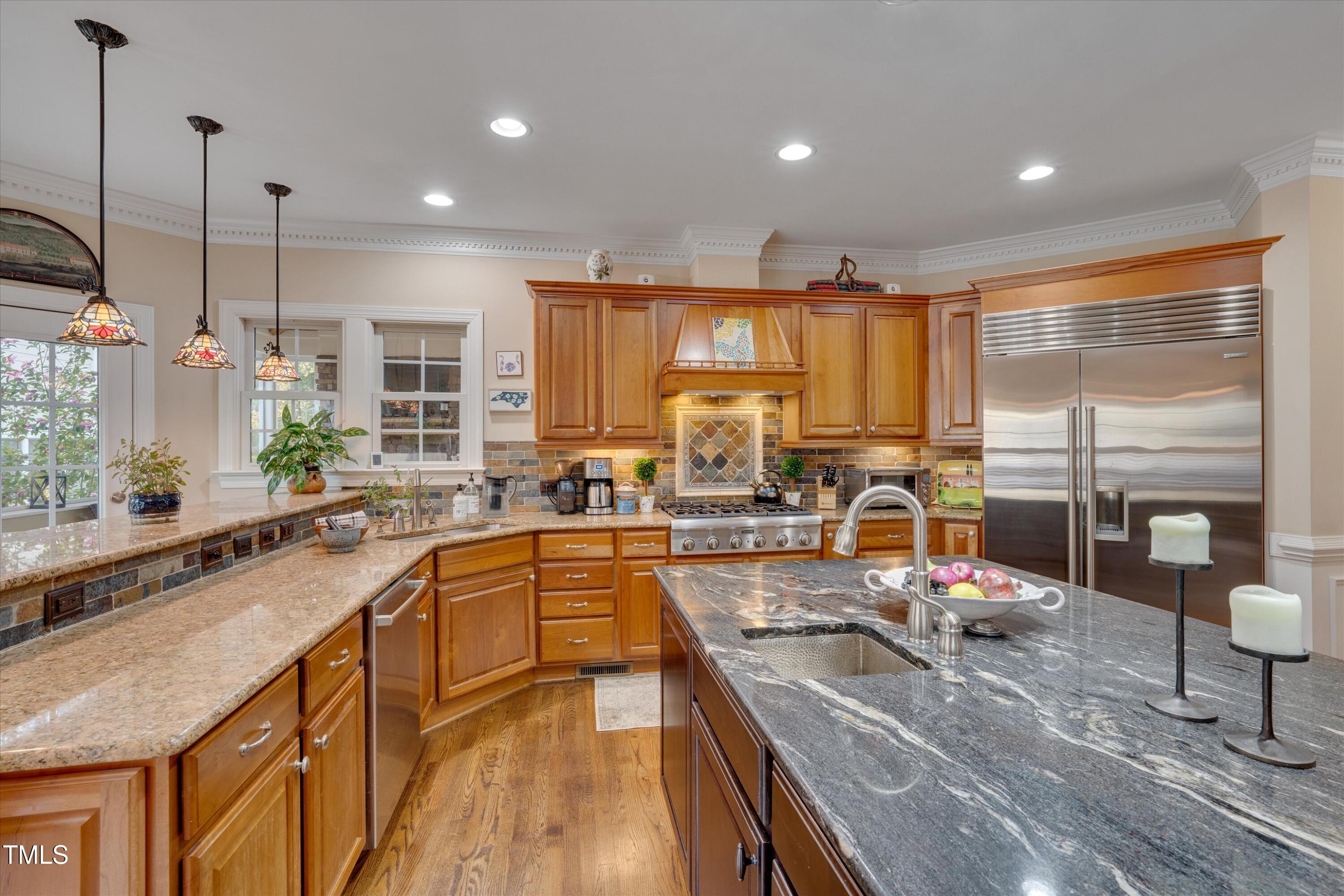 8308 Cazavini Court Raleigh, NC 27613 - Photo 10 of 46 a large kitchen with kitchen island granite countertop a large window and a counter space