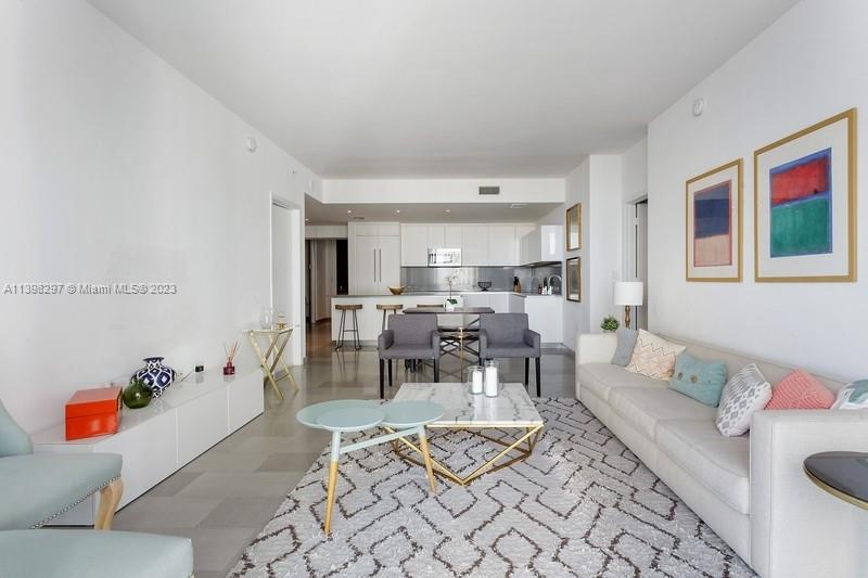 68 Southeast 6th Street, Unit 1209 Miami, FL 33131 - Photo 4 of 15 a living room with furniture and a table
