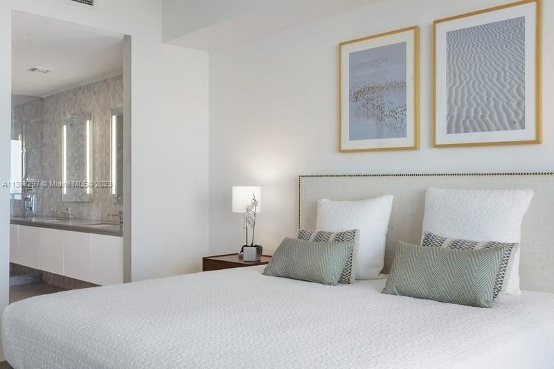 68 Southeast 6th Street, Unit 1209 Miami, FL 33131 - Photo 8 of 15 a large bed sitting in a bedroom next to a window