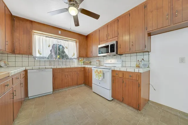 a kitchen with kitchen island a stove a sink and a refrigerator with wooden floor