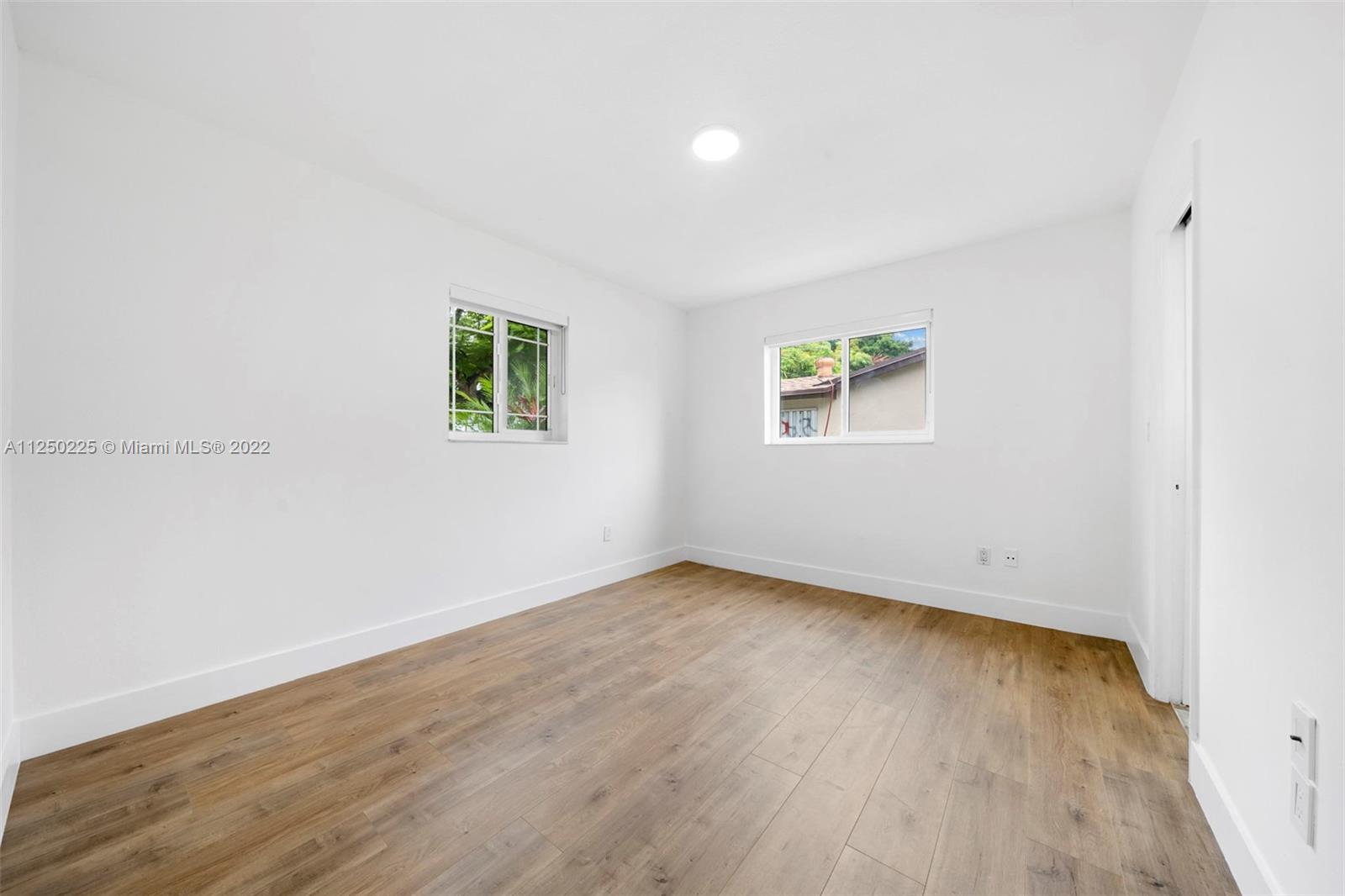 19541 Franjo Road Cutler Bay, FL 33157 - Photo 5 of 28 an empty room with wooden floor and window