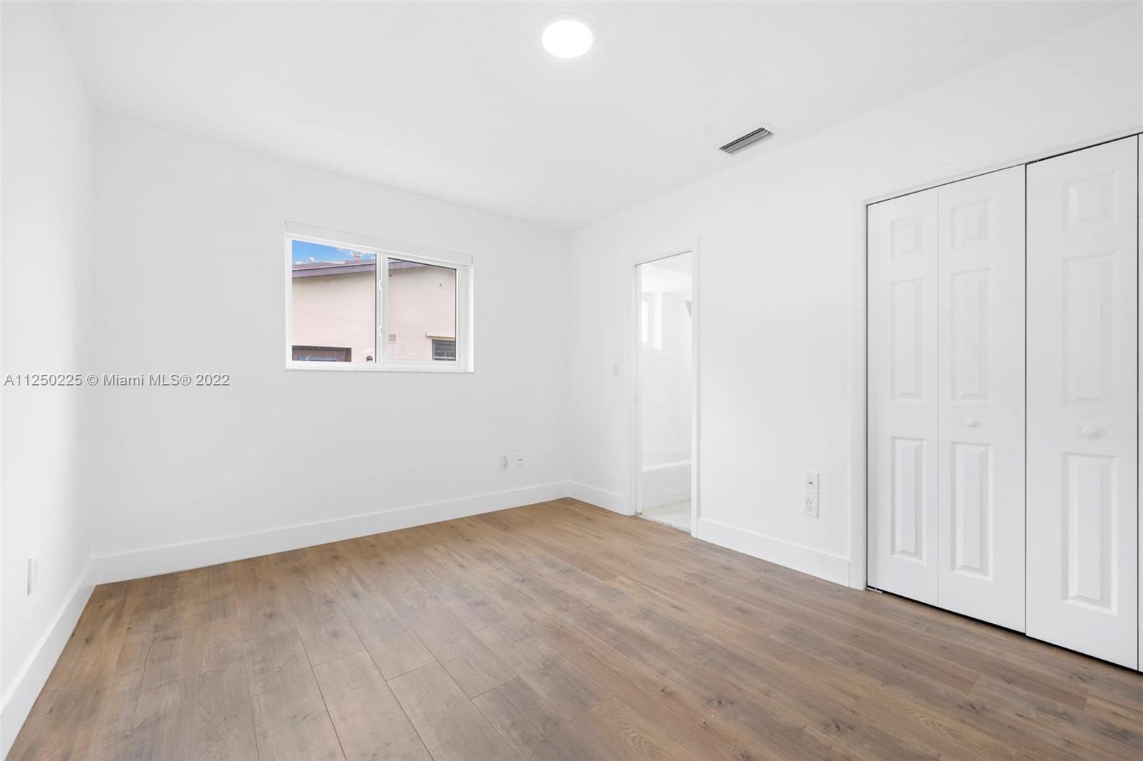 19541 Franjo Road Cutler Bay, FL 33157 - Photo 6 of 28 an empty room with wooden floor and windows