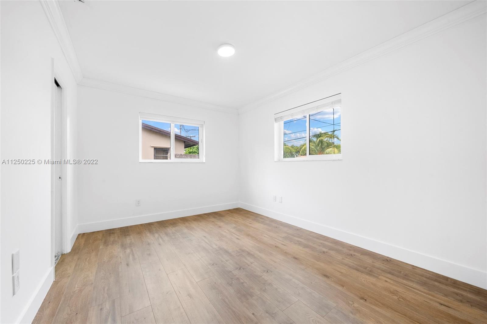 19541 Franjo Road Cutler Bay, FL 33157 - Photo 8 of 28 an empty room with wooden floor and windows