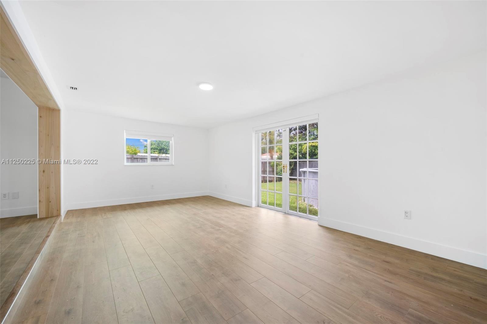19541 Franjo Road Cutler Bay, FL 33157 - Photo 10 of 28 an empty room with wooden floor and windows