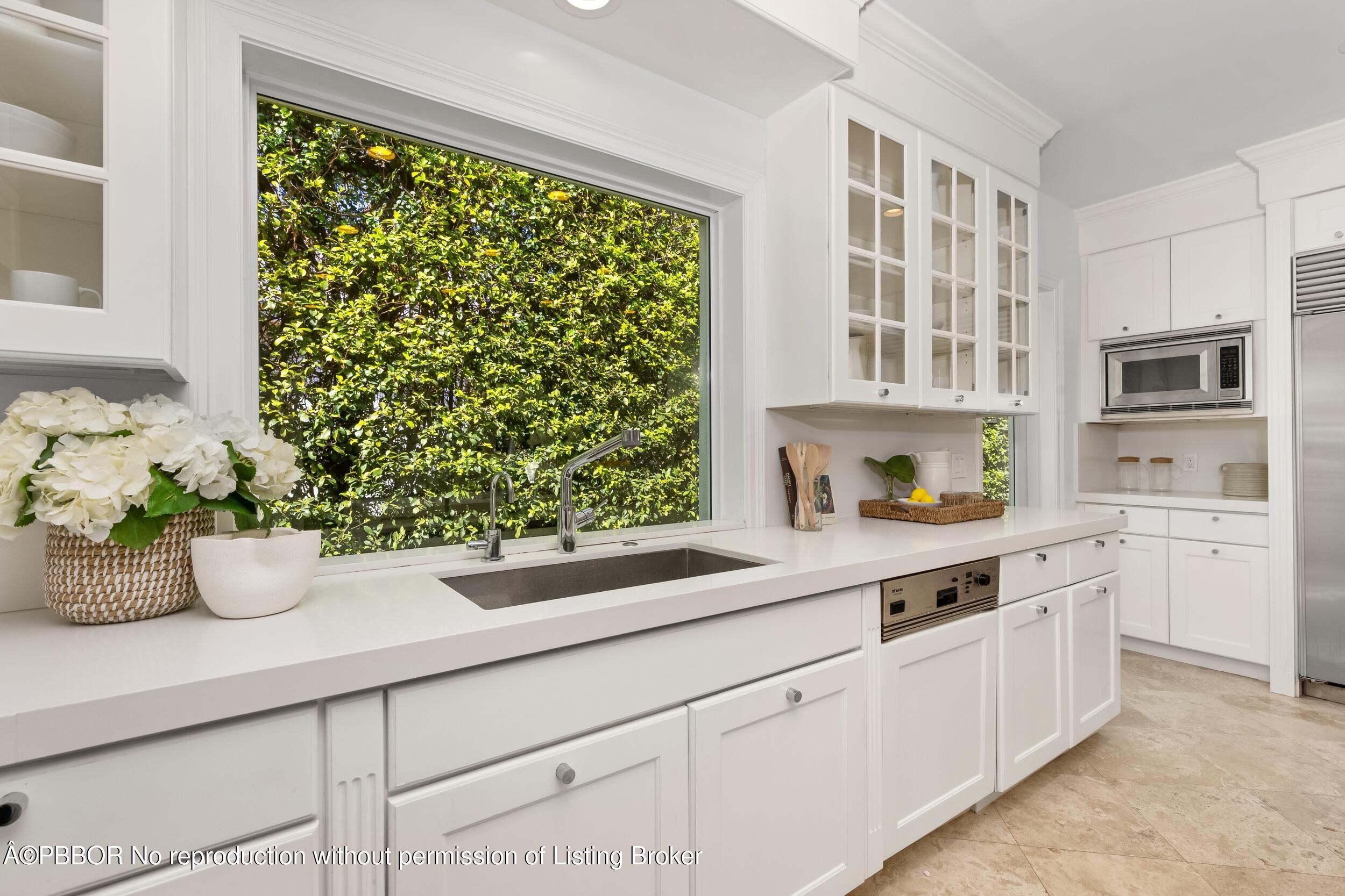 273 List Road Palm Beach, FL 33480 - Photo 33 of 54 a kitchen with a potted plant on the counter and a window