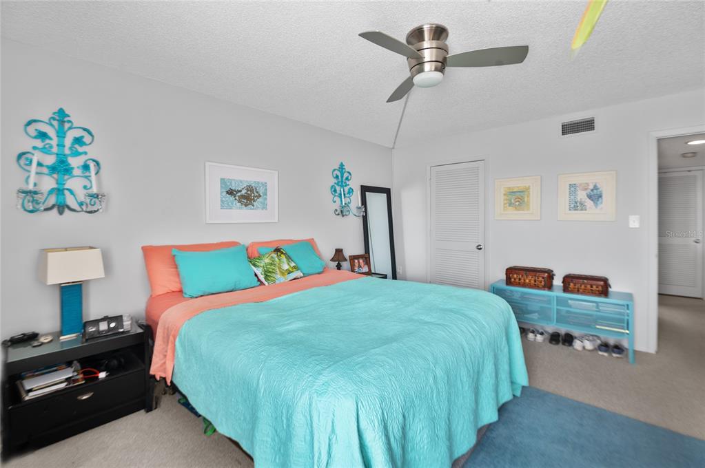 9860 62nd Avenue North, Unit 1047 St. Petersburg, FL 33708 - Photo 12 of 34 a bedroom with a bed and a chandelier