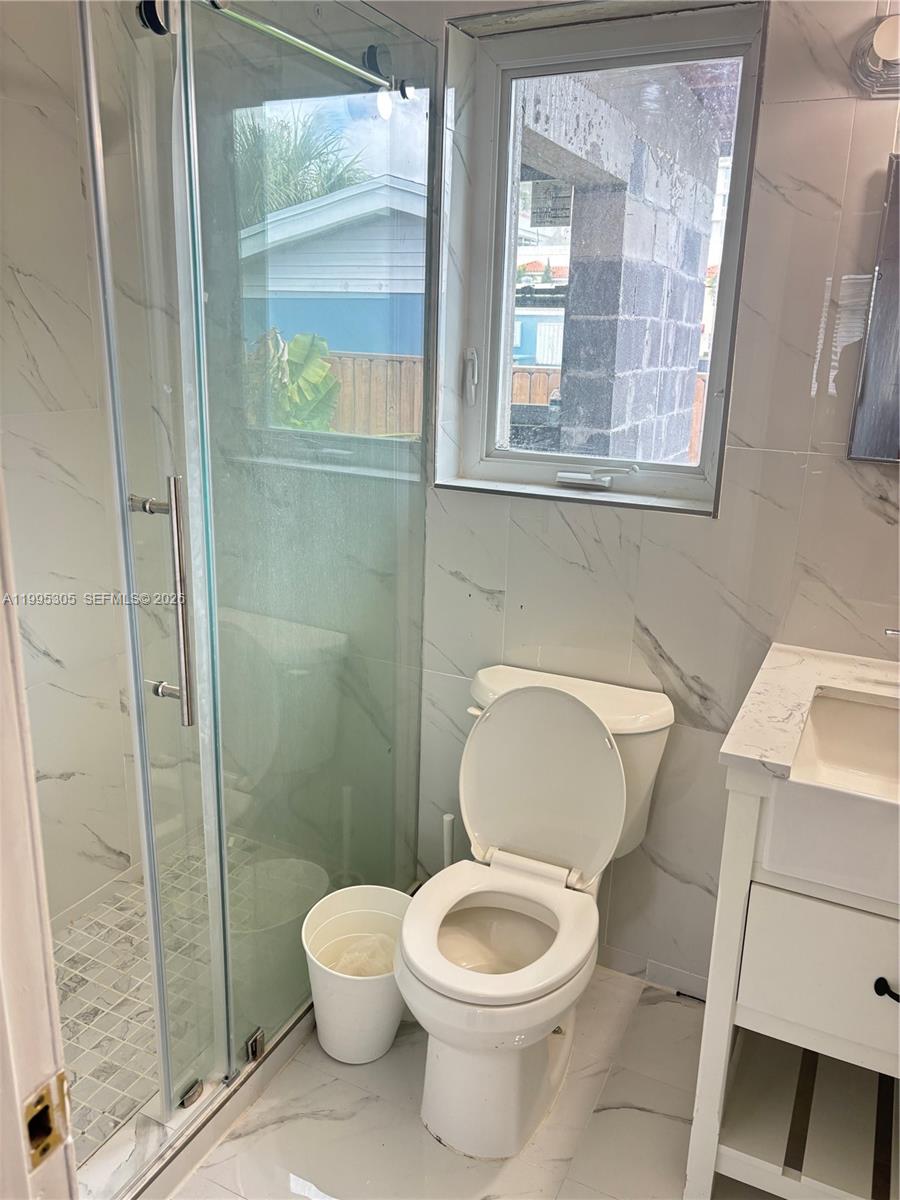 2951 Southwest 23rd Street, Unit 2 Miami, FL 33145 - Photo 3 of 7 a white toilet sitting next to a bathroom sink
