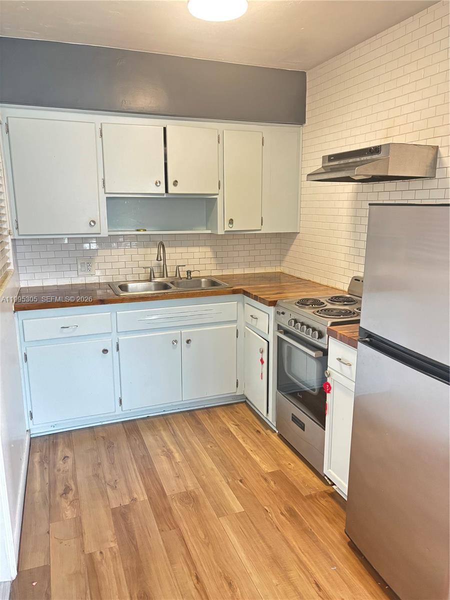 2951 Southwest 23rd Street, Unit 2 Miami, FL 33145 - Photo 4 of 7 a kitchen with granite countertop white cabinets and white appliances