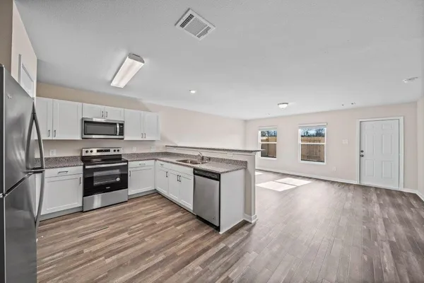 a bathroom with a granite countertop sink a toilet and a bathtub