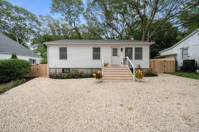 a view of a house with a yard and large tree