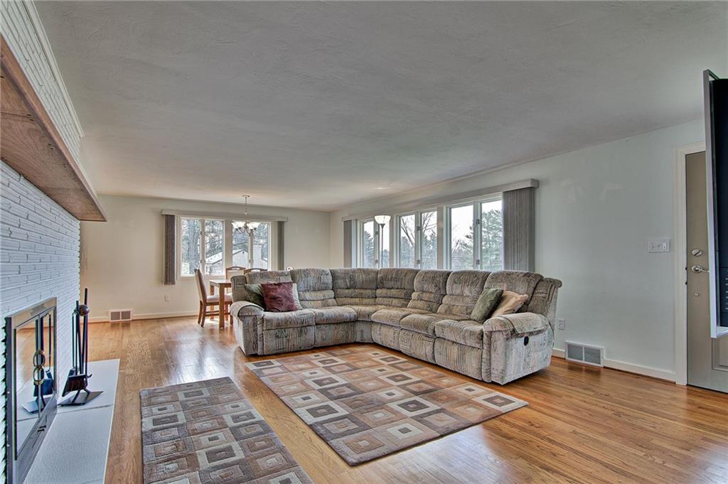 9376 Woodcrest Road Pittsburgh, PA 15237 - Photo 9 of 24 Sweeping view of the open family room ~ Andersen windows add to the light and airy feel of this home! The log burning fireplace completes the setting of this gathering spot.